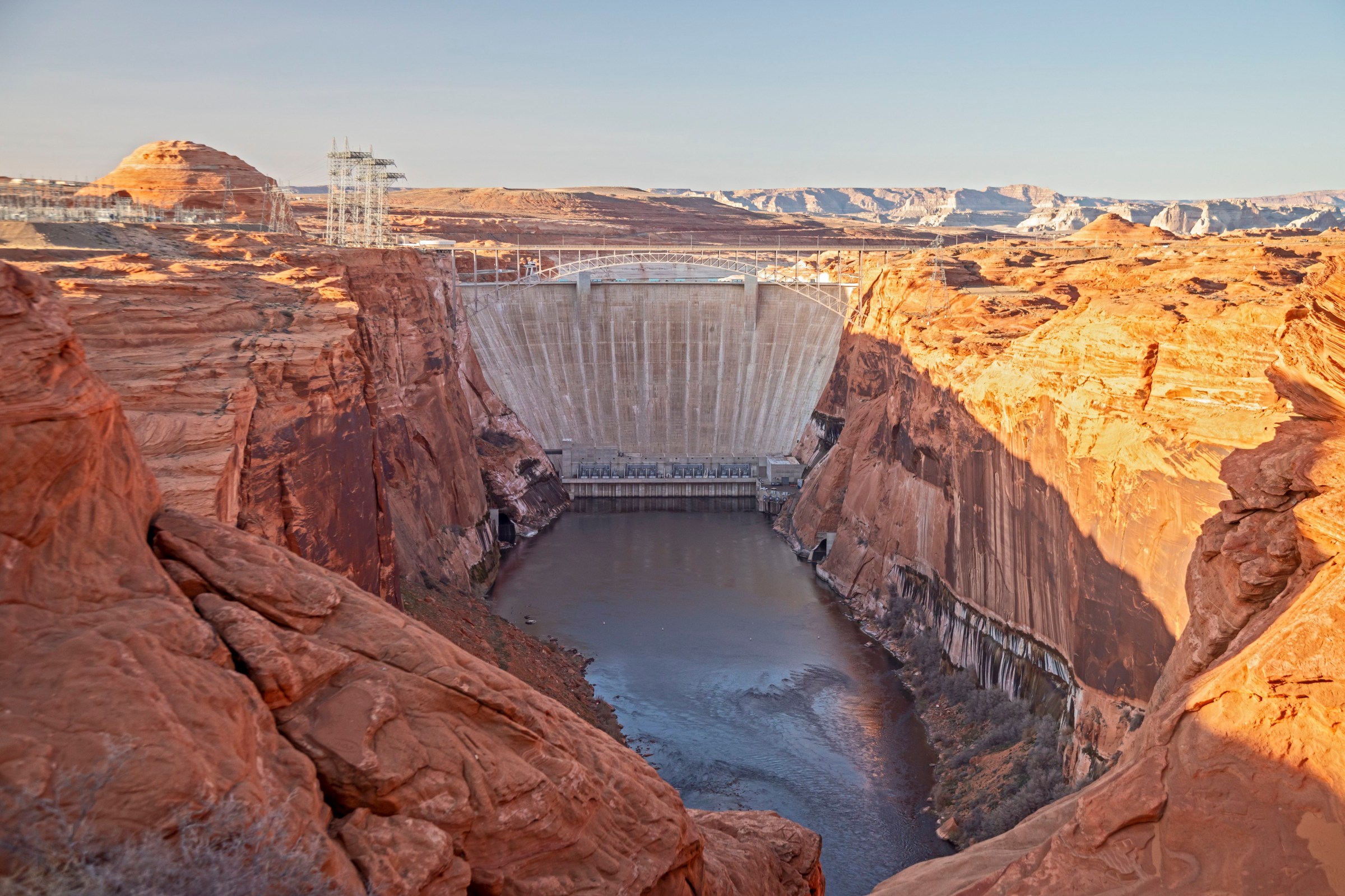 A dam that spans a gorge, and the water level below it is low.